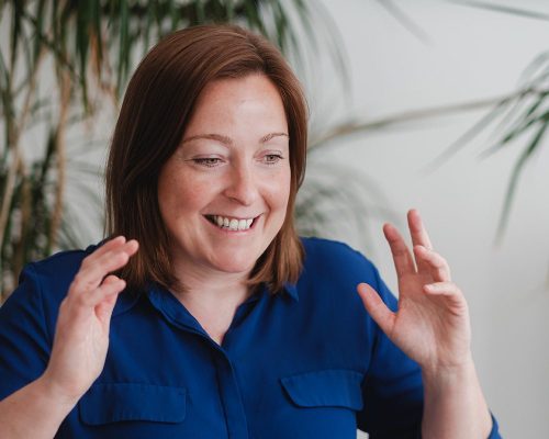 Petra Heytens, freelance copywriter en designer, die enthousiast iets uitlegt.