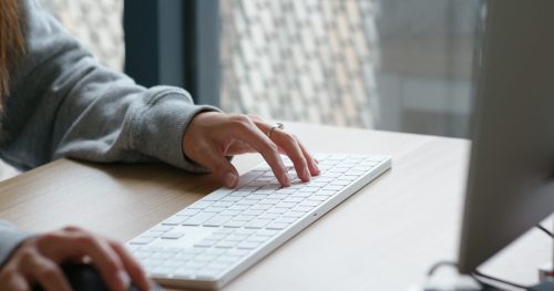 Woman type on desktop computer